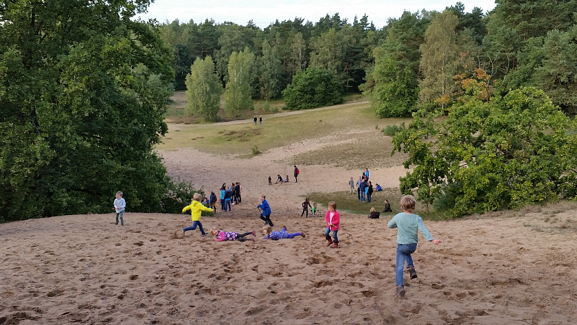Kinder spielen auf einer Düne