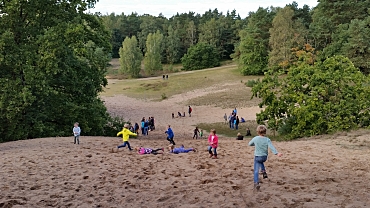 Kinder spielen auf einer Düne